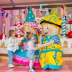 Kinderen begroeten mascottes in kleurrijke omgeving