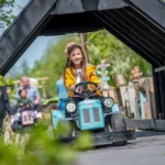 Lachend meisje rijdt op speelgoedtractor in Molenwaard