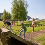Kinderen spelen in de speeltuin met vliegtuigen op de achtergrond