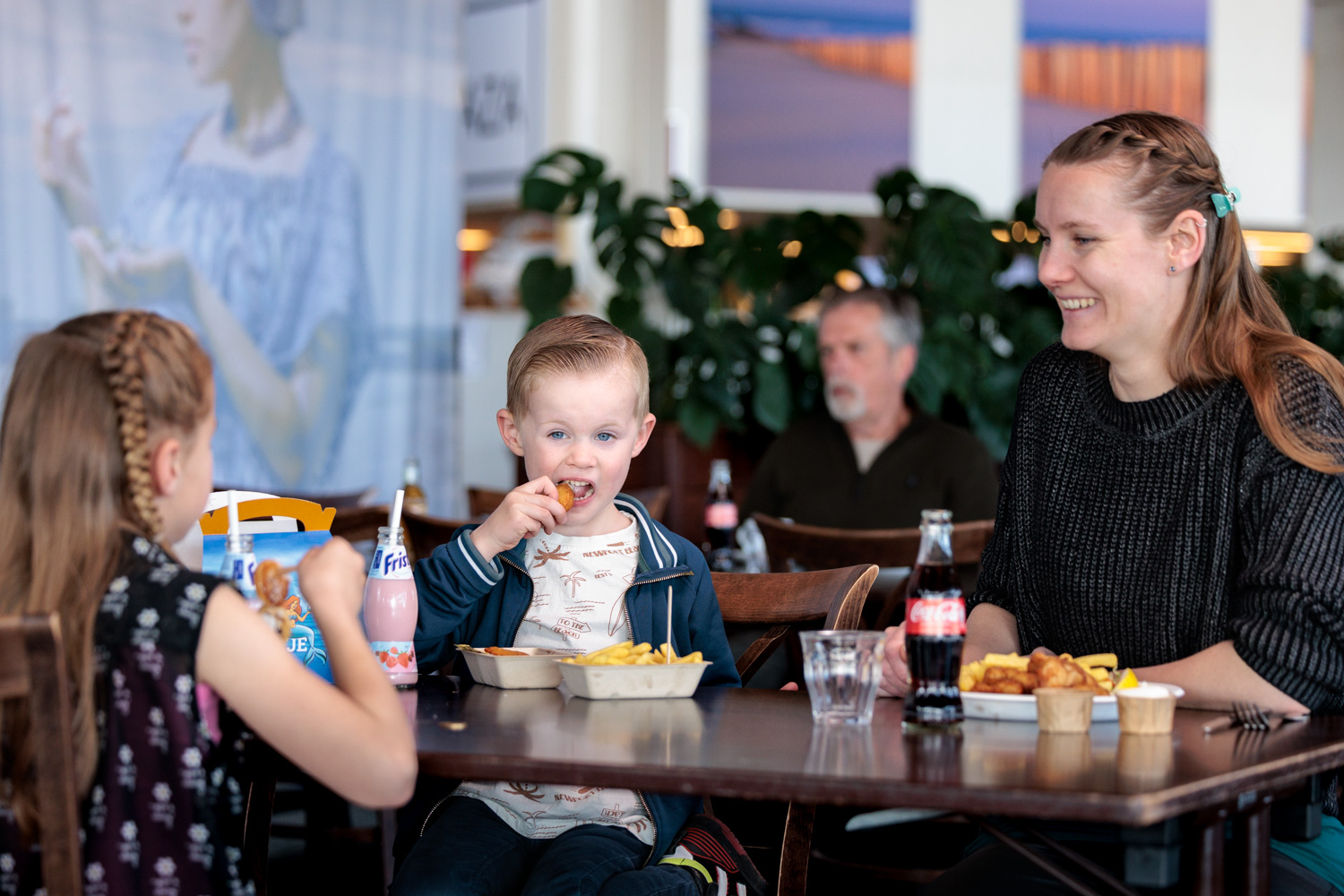 Gezin geniet van een maaltijd in het restaurant van Deltapark Neeltje Jans