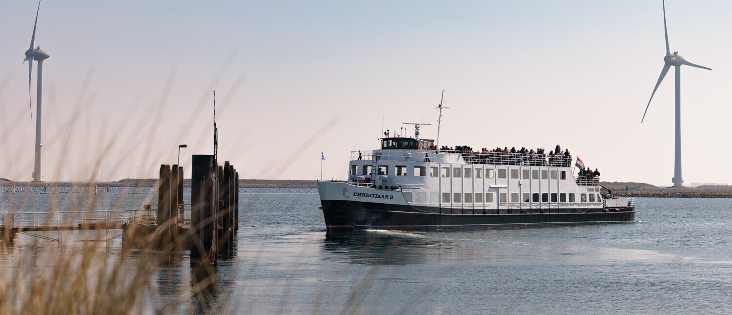 Rondvaartboot op de Oosterschelde met bezoekers aan boord die uitkijken over het water.