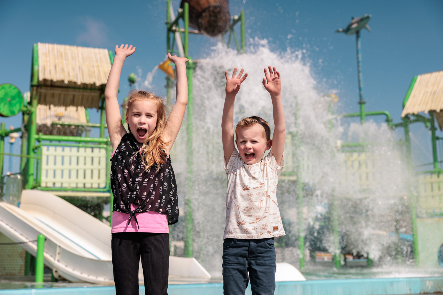 Kinderen juichen terwijl de wateremmer leegkiept in de Aquasplash